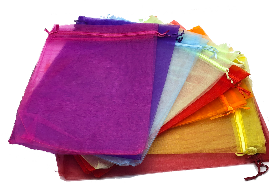 Colorful organza bags stacked on a white background